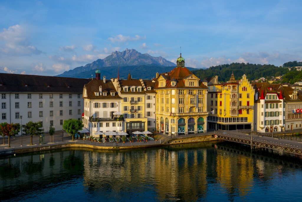Colorful buildings near river surrounded by mountains lucerne switzerland — Suíça